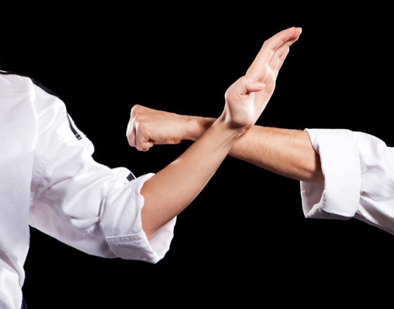 Dos manos fuertes haciendo un bloqueo de Karate, simbolizando al sistema inmune del cuerpo defendiendose de las enfermedades