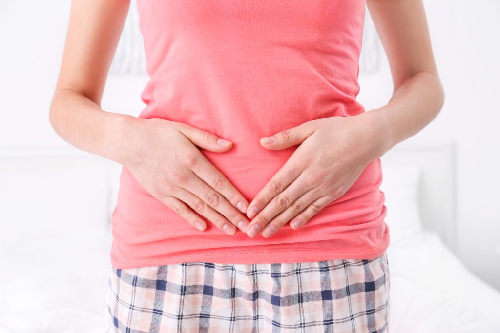 mujer joven con manos en el diafragma y respirando