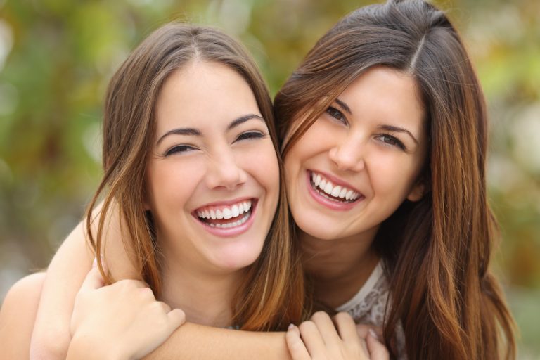 dos mujeres sonriendo mostrando su salud dental