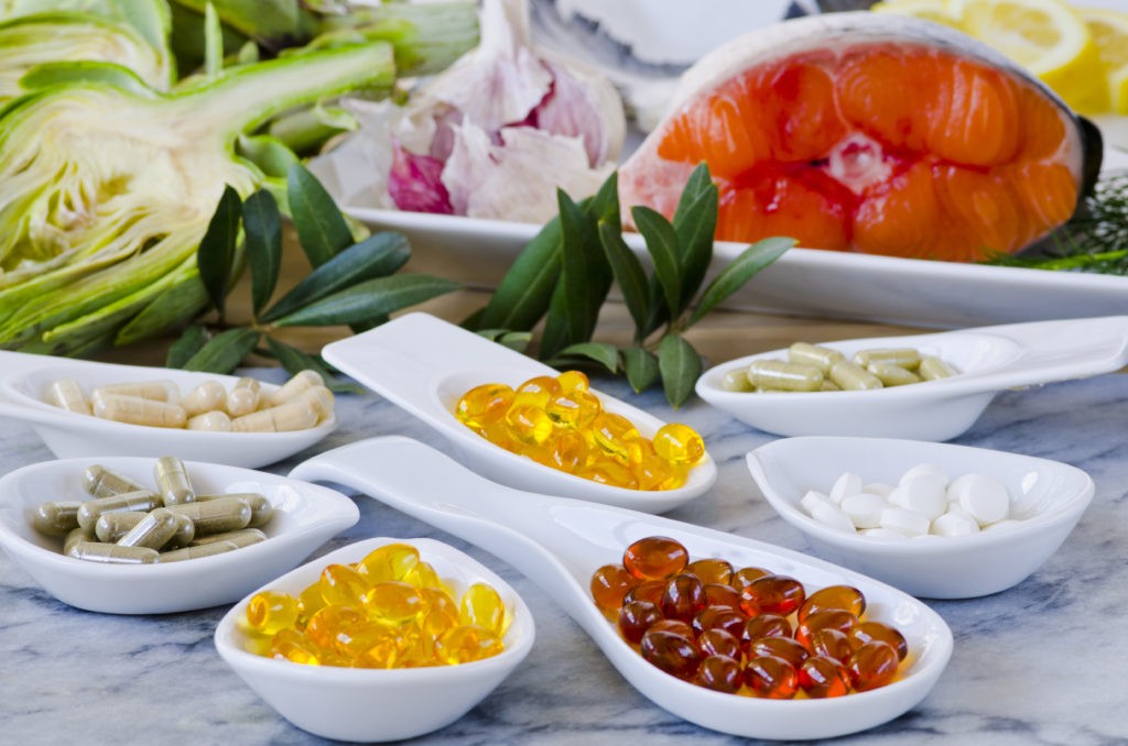 suplementos en recipientes blancos con fuentes alimenticias naturales