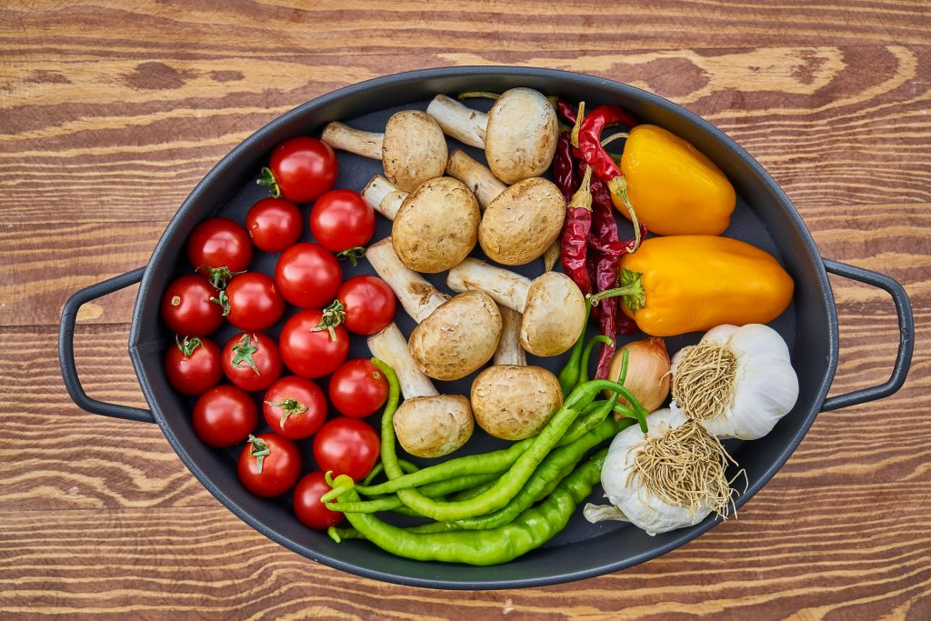 Verduras frescas ricas en polifenoles: tomates, champiñones, chiles, pimientos y ajo en una bandeja